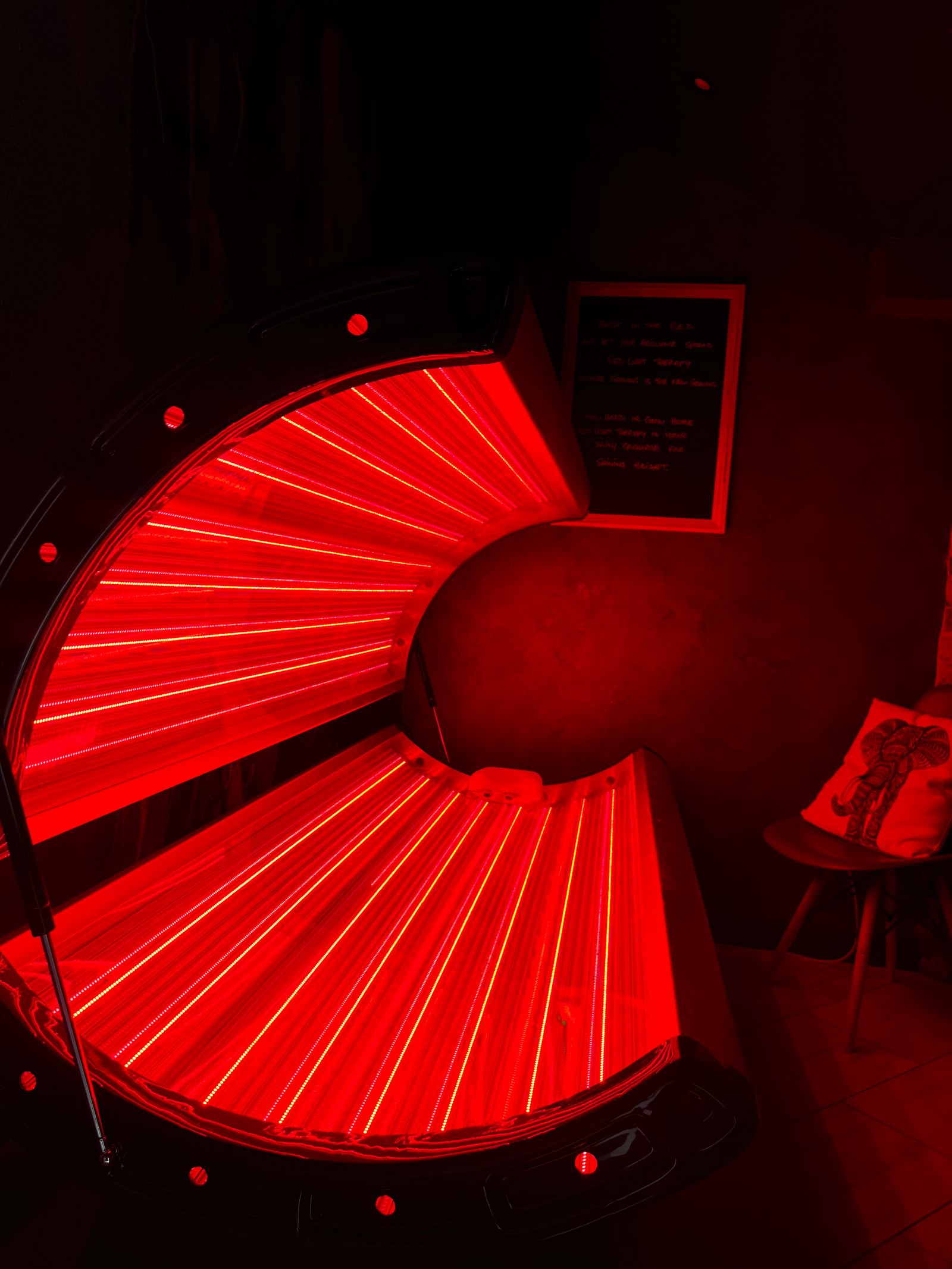 A close view of the illuminated red-light therapy bed.